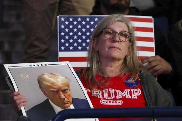 An attendee listens as former President Donald Trump speaks at a campaign rally, Saturday Dec. 16, 2023, in Durham, N.H. (AP Photo/Reba Saldanha)