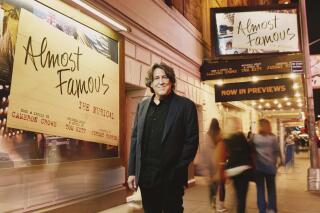 Cameron Crowe poses outside the the Bernard B. Jacobs Theatre in New York on Oct. 27, 2022. Crowe has turned his autobiographical coming-of-age film “Almost Famous” into a Broadway stage musical. The show, now in previews, opens Nov. 3. (Emilio Madrid via AP)
