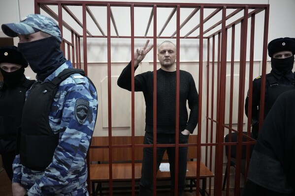 Sergei Udaltsov, Russian left-wing political activist stands in a cage in a courtroom in Moscow, Russia, Friday, Jan. 12, 2024. Sergei Udaltsov, a Russian pro-war activist and critic of President Vladimir Putin, was remanded into custody Thursday over alleged terrorism offenses, his lawyer told the Russian state news agency Tass. (AP Photo/Alexander Zemlianichenko)