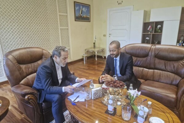 In this photo released by the Iranian Foreign Ministry, Iranian Foreign Minister Abbas Araghchi, left, reads a paper in a meeting with his Omani counterpart Sayyid Badr Albusaidi at the Omani Embassy in Rome during the fifth round of Iran-U.S. negotiations, Friday, May 23, 2025. (Iranian Foreign Ministry via AP)