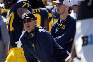 Michigan head coach Jim Harbaugh, front left, watches against Rutgers as analytics assistant Connor Stalions, right, looks on during an NCAA college football game in Ann Arbor, Mich., Sept. 23, 2023. Stalions was suspended by the university last week and is at the center of a sign-stealing scheme that is being investigated by the NCAA. (AP Photo/Paul Sancya)