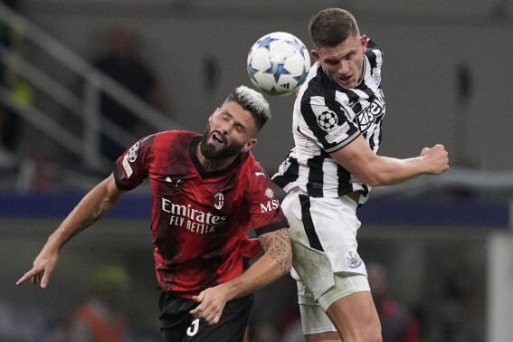 AC Milan's Olivier Giroud, left, goes for the header with Newcastle's Sven Botman during the Champions League group F soccer match between AC Milan and Newcastle at the San Siro stadium in Milan, Italy, Tuesday, Sept. 19, 2023. (AP Photo/Antonio Calanni)