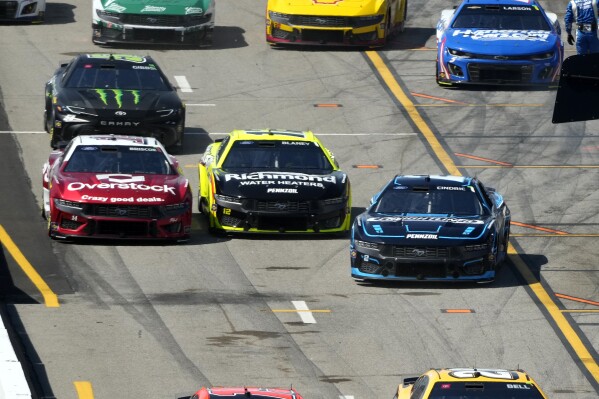 Austin Cindric, right, exits his pit stall as Ryan Blaney, center, and Chase Briscoe, left, follow during a NASCAR Cup Series auto race at World Wide Technology Raceway Sunday, June 2, 2024, in Madison, Ill. (AP Photo/Jeff Roberson)