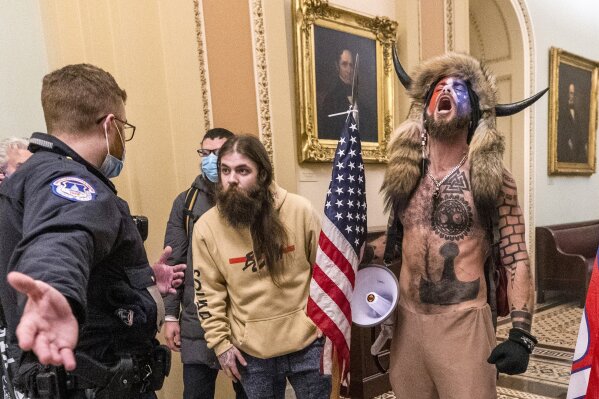 FILE - In this Wednesday, Jan. 6, 2021 file photo, supporters of President Donald Trump, including Jacob Chansley, right with fur hat, are confronted by U.S. Capitol Police officers outside the Senate Chamber inside the Capitol in Washington. Congress is set to hear from former security officials about what went wrong at the U.S. Capitol on Jan. 6. That's when when a violent mob laid siege to the Capitol and interrupted the counting of electoral votes. Three of the four testifying Tuesday resigned under pressure immediately after the attack, including the former head of the Capitol Police. (AP Photo/Manuel Balce Ceneta, File)