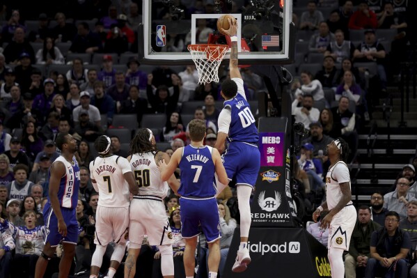 Sacramento Kings center JaVale McGee (00) dunks the ball against the Denver Nuggets during the first half of an NBA basketball game in Sacramento, Calif, Saturday, Dec. 2, 2023. (AP Photo/Jed Jacobsohn)