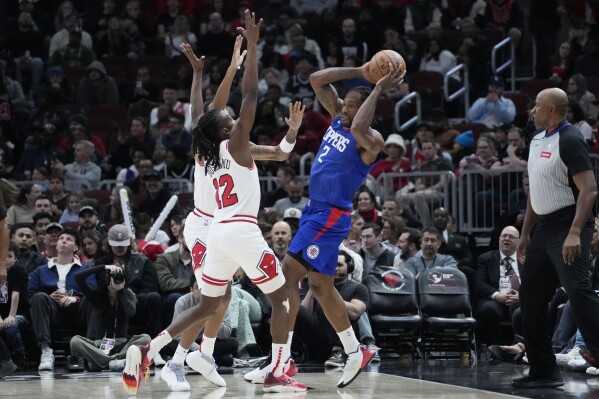 Los Angeles Clippers forward Kawhi Leonard, center right, looks to pass as Chicago Bulls forward Dalen Terry, back left, and guard Ayo Dosunmu, front left during the first half of an NBA basketball game in Chicago, Thursday, March 14, 2024. (AP Photo/Nam Y. Huh)