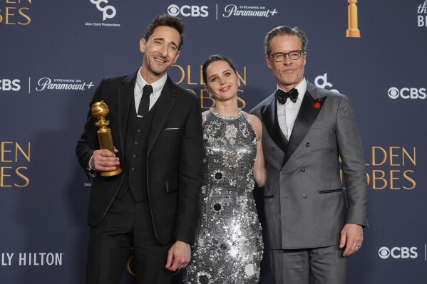 Adrien Brody, winner of the award for best performance by a male actor in a motion picture drama for "The Brutalist", from left, Felicity Jones, and Guy Pearce pose in the press room during the 82nd Golden Globes on Sunday, Jan. 5, 2025, at the Beverly Hilton in Beverly Hills, Calif. (AP Photo/Chris Pizzello)