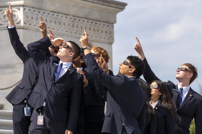 يرتدي المتسابقون في مجلس الشيوخ نظارات الكسوف وهم يشاهدون القمر يغطي الشمس جزئيًا أثناء كسوف الشمس الكلي، أمام مجلس الشيوخ الأمريكي في الكابيتول هيل، الاثنين 8 أبريل 2024، في واشنطن. (صورة AP / أليكس براندون)