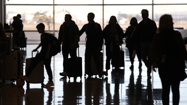 FILE - People pass through Salt Lake City International Airport on Wednesday, Jan. 11, 2023, in Salt Lake City. Thirty percent of Americans don't identify with a religious group — but not all of them are atheists or agnostics. In fact, 43% of the group known as the "nones" say they believe in God, even if they largely dislike organized religion. (AP Photo/Rick Bowmer, File)