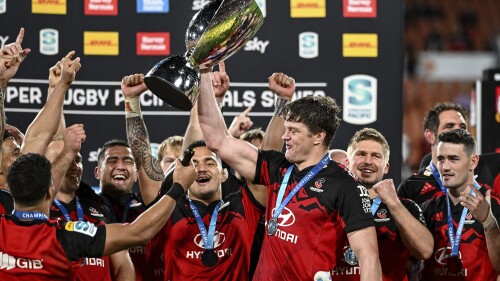 Crusaders captain Scott Barrett holds the trophy aloft as he celebrates with teammates after defeating the chiefs in the Super Rugby Pacific final in Hamilton, New Zealand, Saturday, June 24, 2023. (Andrew Cornaga/Photosport via AP)