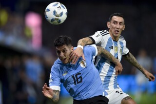 Argentina's Angel Di Maria, right, and Uruguay's Mathias Olivera battle for the ball during a qualifying soccer match for the FIFA World Cup 2026 at La Bombonera stadium in Buenos Aires, Argentina, Thursday, Nov. 16, 2023. (AP Photo/Gustavo Garello)