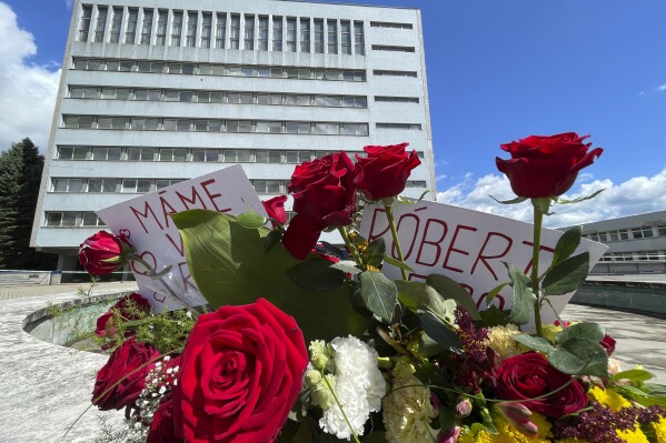 Flores frente al hospital donde está el primer ministro eslovaco Robert Fico tras ser víctima de un atentado, en Banska Bystrica, Eslovaquia, el 18 de mayo de 2024. (AP Foto/Lefteris Pitarakis)