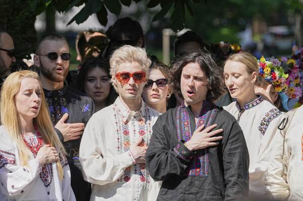 Eurovision band Ziferblat of Ukraine sings their national anthem with Ukrainian people during a family meeting in a park in Basel as part of the 69th Eurovision Song Contest week, in Basel, Switzerland, Thursday, May 15, 2025. (AP Photo/Martin Meissner)