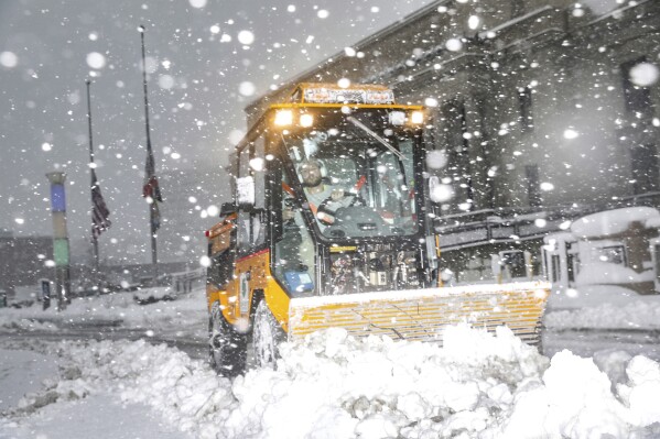 City teams remove snow as it falls during a blizzard on Tuesday, Jan. 9, 2024, at the Linn County Courthouse in Cedar Rapids, Iowa. (Geoff Stellfox/The Gazette via AP)