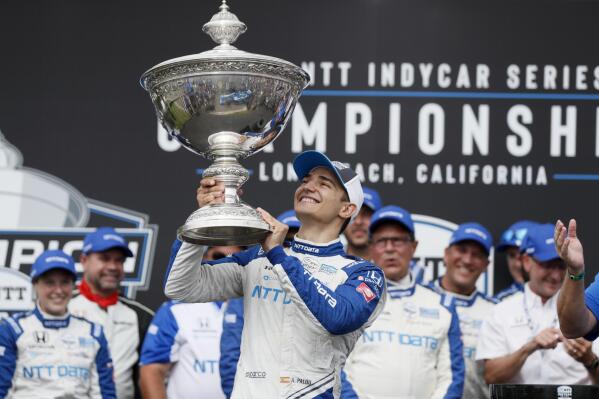 FILE  -NTT IndyCar Series winner Alex Palou, center, celebrates with the trophy after taking 4th place in an IndyCar auto race at the Grand Prix of Long Beach, Sunday, Sept. 26, 2021, in Long Beach, Calif. The stars of IndyCar crowded into Indianapolis Motor Speedway to celebrate an upcoming season of opportunity for America's open-wheel racing series to reestablish its legitimacy and expand its popularity. The party was held just one week before IndyCar's drivers hit the streets of St. Petersburg for the first practice session of the season. (AP Photo/Alex Gallardo, File)