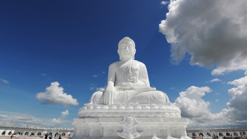 Laborers work while visitors stand below the sitting Maravijaya Buddha marble statue, Friday, July 21, 2023, in Naypyitaw, Myanmar. The Maravijaya Buddha statue is said to be the world’s highest sitting marble Buddha image according to local media. (AP Photo/Aung Shine Oo)