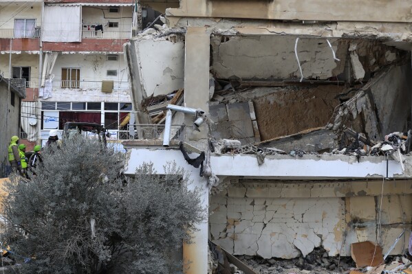 Civil defence and rescue workers remove rubbles from a building that was attacked Wednesday night by an Israeli airstrike, in Nabatiyeh town, south Lebanon, Thursday, Feb. 15, 2024. The airstrike killed and injured several people and child, Lebanon's state news agency reported. (AP Photo/Mohammed Zaatari)