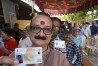 A man shows his voter's identity card as he queues up with others to vote during the second round of voting in the six-week-long national election near Palakkad, in Indian southern state of Kerala, Friday, April 26, 2024. (AP Photo/Manish Swarup)