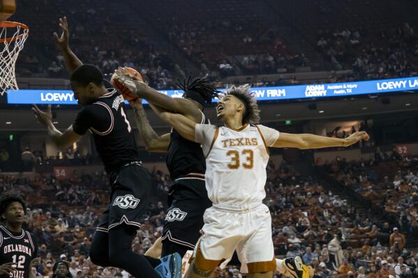 Texas forward Tre Mitchell, right, goes up for a rebound against Oklahoma State guard Issac Likekele, center, and guard Bryce Thompson, left, during the first half of an NCAA college basketball game, Saturday, Jan. 22, 2022, in Austin, Texas. (AP Photo/Michael Thomas)