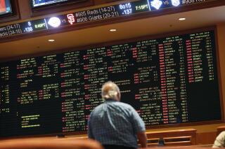 FILE - In this May 14, 2018 file photo, betting odds are displayed on a board in the sports book at a hotel casino in Las Vegas. A former minor league pitcher was the ringleader of an illegal sports betting operation in California that included current and former pro athletes, federal prosecutors said. Wayne Nix agreed to plead guilty to conspiring to run an illegal gambling operation, Thursday, March 31, 2022 (AP Photo/John Locher, File)