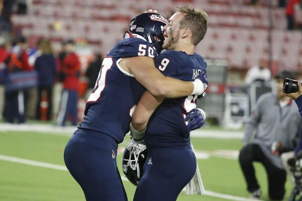 Fresno State quarterback Jake Haener, right, gets a hug from defensive lineman Charles Remlinger after a come-from-behind win against San Diego State during the second half of an NCAA college football game in Fresno, Calif., Saturday, Oct. 29, 2022. (AP Photo/Gary Kazanjian)