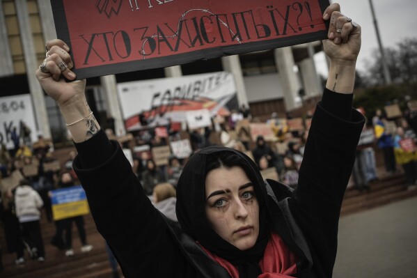 A woman holds a sign during a protest in Kyiv, Ukraine, Sunday March 24, 2024, to demand the freedom of Ukrainian Mariupol's Azovstal defenders still being held prisoners by Russia. (AP Photo/Enric Marti)