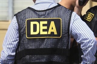 FILE - This June 13, 2016 file photo shows Drug Enforcement Administration (DEA) agents in Florida. A once-standout U.S. narcotics agent has admitted conspiring to launder money with a Colombian drug cartel. Jose Irizarry pleaded guilty Monday, Sept. 14, 2020 in Tampa, Fla., to federal bank fraud, conspiracy and other charges. (Joe Burbank/Orlando Sentinel via AP, File)