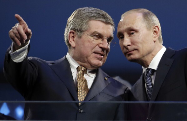 FILE - International Olympic Committee President Thomas Bach, left, and Russian President Vladimir Putin watch the closing ceremony of the 2014 Winter Olympics, in Sochi, Russia, on Sunday, Feb. 23, 2014. Russia sought to impress the world and expand its global prestige by hosting the expensive Olympics ever. (AP Photo/Charlie Riedel, File)