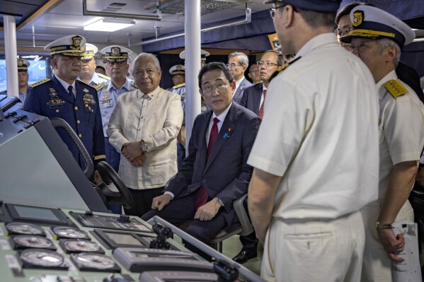 Japan's Prime Minister Fumio Kishida, center, sits on the bridge of the BRP Teresa Magbanua ship at the Philippine Coast Guard headquarters on Saturday Nov. 4, 2023 in Manila, Philippines. (Ezra Acayan/Pool Photo via AP)