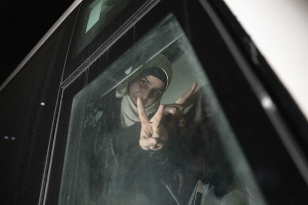 Former Palestinian female prisoners who were released by the Israeli authorities, flash the "V" sign inside their transportation upon their arrival in the West Bank town of Beitunia, Friday, Nov. 24, 2023. The release came on the first day of a four-day cease-fire deal between Israel and Hamas during which the Gaza militants have pledged to release 50 hostages in exchange for 150 Palestinians imprisoned by Israel. (AP Photo/Nasser Nasser)