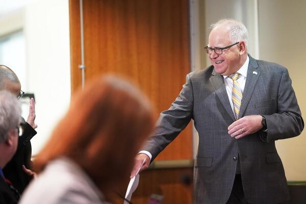 Minnesota Gov. Tim Walz is maskless but wore a big smile as he arrives for a press conference Monday, May 17, 2021, in St. Paul, Minn., to announce that he and the Legislature had agreed to spend $52 billion on the next two-year budget. (David Joles/Star Tribune via AP)