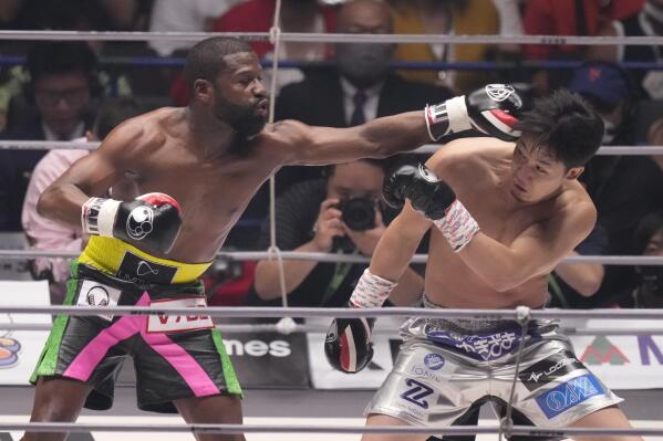 Boxer Floyd Mayweather of the U.S. throws a punch against mixed martial artist Mikuru Asakura of Japan in Saitama, north of Tokyo, Sunday, Sept. 25, 2022. (AP Photo/Hiro Komae)