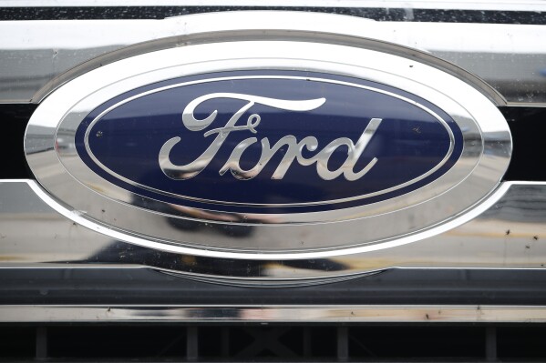 FILE - This Oct. 20, 2019 file photo shows the Ford company logo at a Ford dealership in Littleton, Colo. Ford Motor Co. is resuming construction on a Michigan electric vehicle battery plant that the company postponed two months ago during a strike by the United Auto Workers union. Spokesman Mark Truby said Tuesday, Nov. 21, 2023 that the company looked at growth forecasts for electric vehicle sales, its EV product plans and whether it could make a sustainable business out of the factory in Marshall, about 100 miles west of Detroit. (AP Photo/David Zalubowski, File)