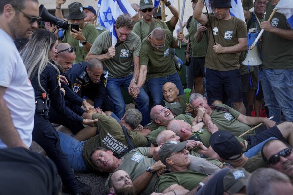 Israeli police disperse demonstrators, mostly military reservists, who block a road outside the house of Israeli Justice Minister Yariv Levin during a protest against plans by Prime Minister Benjamin Netanyahu's government to overhaul the judicial system, in Modiin, Israel, Monday, Sept. 11, 2023. (AP Photo/Ohad Zwigenberg)