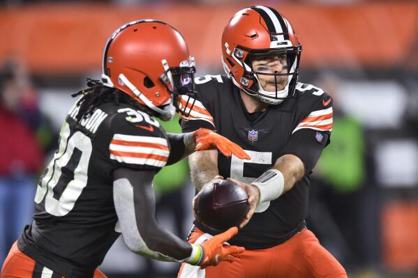 Cleveland Browns quarterback Case Keenum (5) hands the ball off to running back D'Ernest Johnson (30) during the second half of the team's NFL football game against the Denver Broncos, Thursday, Oct. 21, 2021, in Cleveland. (AP Photo/David Richard)