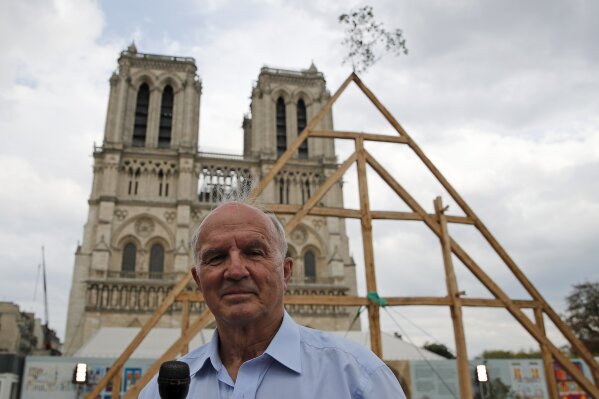 General Jean-Louis Georgelin who is to oversee reconstruction of Notre Dame Cathedral, attends an interview after carpenters put the skills of their Medieval colleagues on show on the plaza in front of Notre Dame Cathedral in Paris, France, Saturday, Sept. 19, 2020, the day honoring European heritage, by reproducing for the public a section of the elaborate carpentry used when the edifice was built. The elaborate wooden beams went up in flames in a devastating April 2019 fire that also toppled the spire of the cathedral, now being renovated. (AP Photo/Francois Mori)