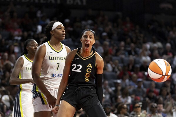 Las Vegas Aces forward A'ja Wilson (22) celebrates after Dallas Wings center Teaira McCowan (7) was charged with a foul during the second half Game 1 of a WNBA basketball semifinal series Sunday, Sept. 24, 2023, in Las Vegas.(Ellen Schmidt/Las Vegas Review-Journal via AP)