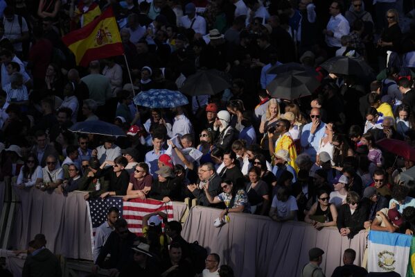 People wait in St. Peter's Square where 133 cardinals are gathering on the second day of the conclave to elect a successor of late Pope Francis, at the Vatican, Thursday, May 8, 2025. (AP Photo/Gregorio Borgia)