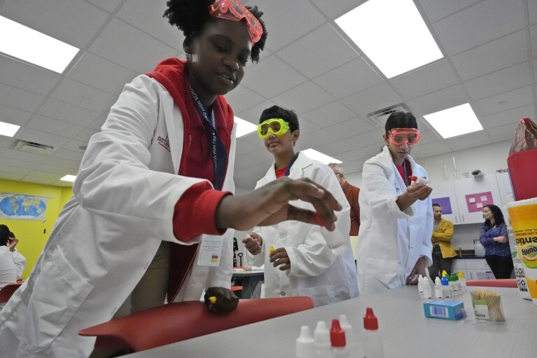 Marisha Valbrun, 12, picks out a vial of fake neurotoxins to test in her Medical Detectives class, Monday, April 15, 2024, at A.D. Henderson School in Boca Raton, Fla. While many teachers nationally complain their districts dictate textbooks and course work, the South Florida school's administrators allow their staff high levels of classroom creativity...and it works. (AP Photo/Wilfredo Lee)