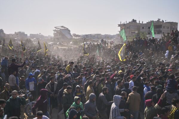 People surround the cars carrying Israeli Gadi Mozes and Arbel Yahoud, who have been held hostages by Hamas in Gaza since October 7, 2023, as they are escorted by Hamas and Islamic Jihad fighters as they are handed over to the Red Cross in Khan Younis, southern Gaza Strip, Thursday Jan. 30, 2025.(AP Photo/Abdel Kareem Hana)