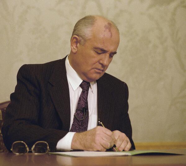 FILE - Mikhail Gorbachev, the final leader of the Soviet Union, signs the decree relinquishing control of nuclear weapons to Boris Yeltsin at the Kremlin in Moscow, Wednesday, Dec. 25, 1991. Gorbachev announced his resignation in a live televised address to the nation on Dec. 25, 1991, drawing a line under more than 74 years of Soviet history. By the fall of 1991, however, deepening economic woes and secessionist bids by Soviet republics had made the collapse of the USSR all but inevitable. The failed August 1991 hardliner coup was a major catalyst, dramatically eroding Gorbachev's authority and encouraging more republics to seek independence. (AP Photo/Liu Heung Shing, File)
