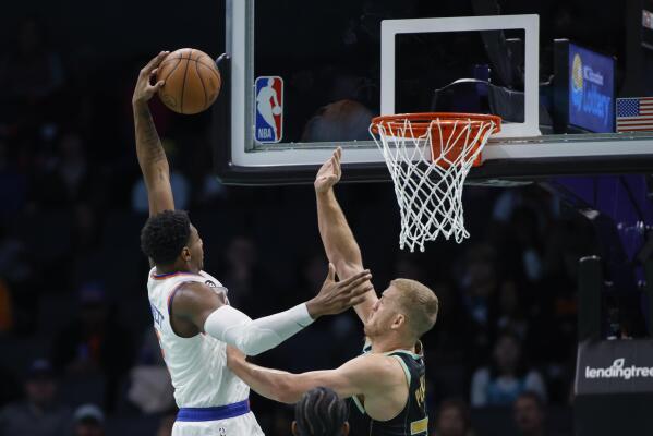 New York Knicks guard RJ Barrett, left, drives for a dunk against Charlotte Hornets center Mason Plumlee during the first half of an NBA basketball game in Charlotte, N.C., Friday, Dec. 9, 2022. (AP Photo/Nell Redmond)