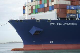 Crew members stand on the bow as the CMA CGM Argentina arrives at PortMiami, the largest container ship to call at a Florida port, Tuesday, April 6, 2021, in Miami.  The U.S. trade deficit grew to $71.1 billion in February, as a decline in exports more than offset a slight dip in imports. The February gap between what America buys from abroad compared to what it sells abroad jumped 4.8% the revised January deficit of $67.8 billion.vThe increase reflected a 2.6% decline in exports of goods and services to $187.3 billion on a seasonally adjusted basis. (AP Photo/Lynne Sladky)