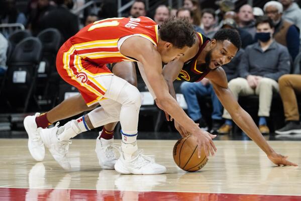 Atlanta Hawks guard Trae Young (11) and Cleveland Cavaliers center Evan Mobley (4) battle for a loose ball during the first half of an NBA basketball game Tuesday, Feb. 15, 2022, in Atlanta. (AP Photo/John Bazemore)