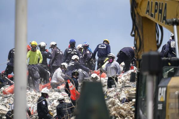 Workers search the rubble at the Champlain Towers South condo, Monday, June 28, 2021, in Surfside, Fla. Many people were still unaccounted for after Thursday's fatal collapse. (AP Photo/Gerald Herbert)
