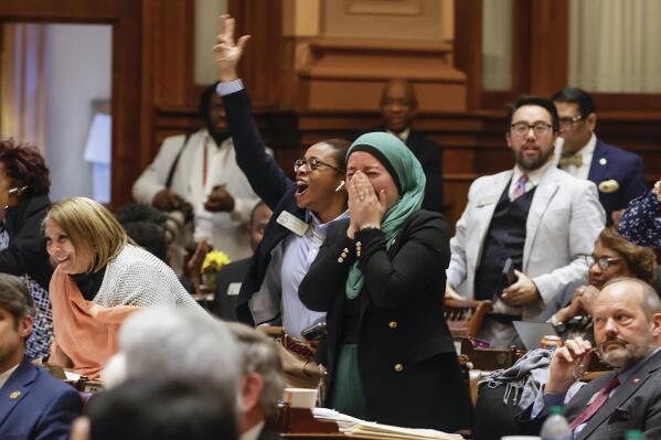 Rep. Imani Barnes, D-Tucker, left, and Rep. Ruwa Romma, D-Duluth, cheer after HB 233 fails to pass on Wednesday, March 29, 2023, in Atlanta. The bill would send $6,000 a year to parents to help cover education-related costs, including private school tuition. (Natrice Miller/Atlanta Journal-Constitution via AP)
