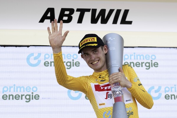 Denmark's Mattias Skjelmose holds the trophy as he celebrates on the podium after winning the Tour de Suisse, during the eighth and final stage, a 25,7 km individual time trial, from St. Gallen to Abtwil, at the 86th Tour de Suisse cycling race, in Abtwil, Sunday, June 18, 2023. (Gian Ehrenzeller/Keystone via AP)
