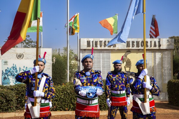 U.N. MINUSMA troops from Bangladesh hoist down the U.N flag for the last time at a departure ceremony held in Bamako, Mali, Monday, Dec. 11, 2023. The United Nations has ended its 10-year peacekeeping mission in Mali following the government's request that alleged the force was inadequate to respond to growing violent extremism in the West African nation. ( Serge Ouedraogo/MINUSMA via AP)