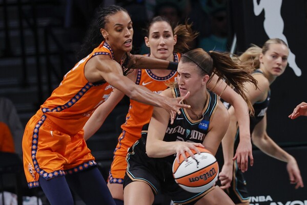 New York Liberty guard Sabrina Ionescu, front right,is defended by Connecticut Sun forward DeWanna Bonner, left, during the second quarter of a WNBA basketball game, Sunday, Sept 24, 2023, in New York. (AP Photo/Eduardo Munoz Alvarez)