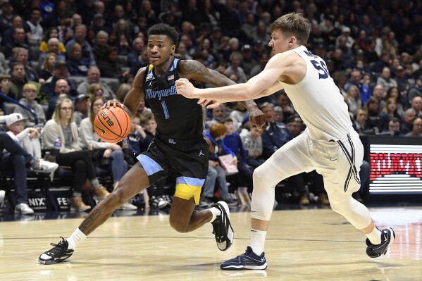 Marquette guard Kam Jones (1) drives around Xavier forward Gytis Nemeiksa (50) during the second half of an NCAA college basketball game in Cincinnati, Saturday, March 9, 2024. Marquette won 86-80. (AP Photo/Timothy D. Easley)